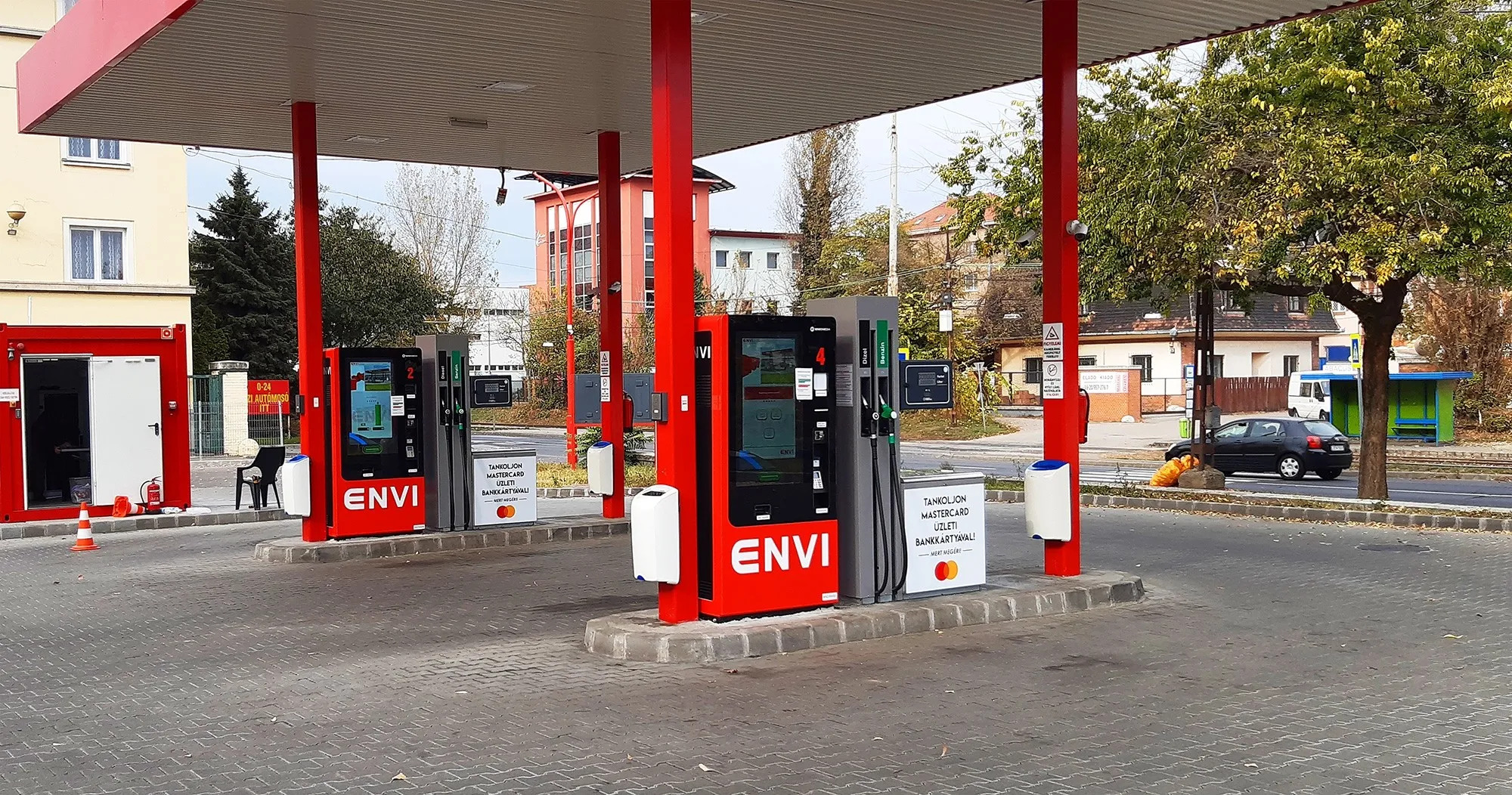 ENVI kút őszi napsütésben, piros tetővel és fizetőautomatákkal